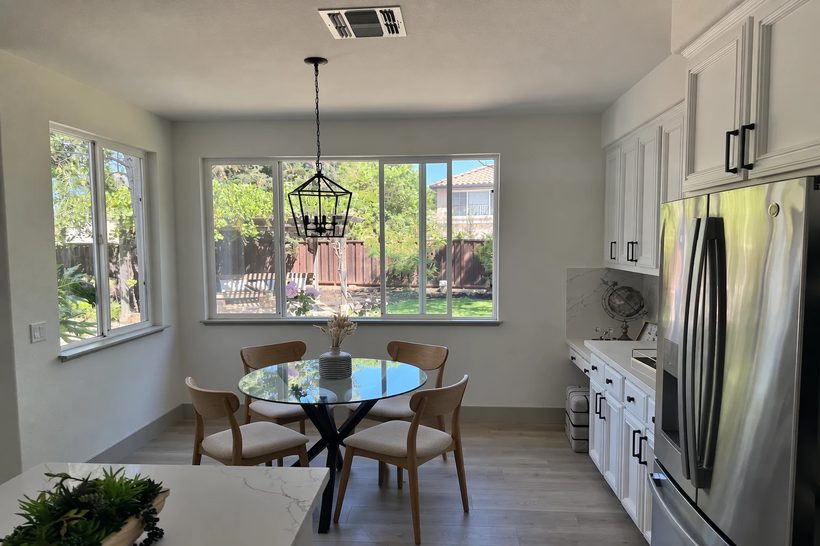 The same kitchen with the white chairs replaced by wooden ones